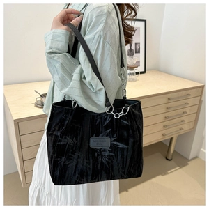Close-up of black jacquard tote bag featuring bamboo leaf texture and silver chain strap