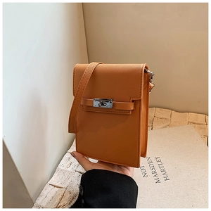 Detail of orange crossgrain leather mini bag featuring a silver twist lock closure