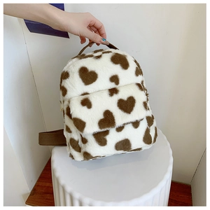 Detail of soft plush backpack with brown heart pattern and front zipper pocket