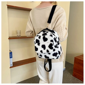 Detail view of heart-shaped cow print plush backpack with adjustable nylon straps