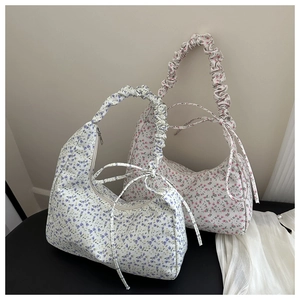 Détail de sacs hobo à fleurs avec poignées plissées et nœuds en rose et violet pastel