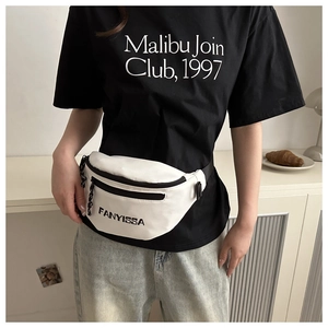 Detailed view of white nylon waist bag with black zippers and adjustable strap worn by model