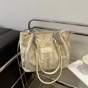 Chic beige textured tote bag with leaf patterns and metal chain strap for women