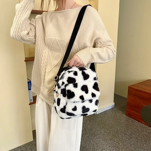 Plush heart print crossbody bag with cow pattern and adjustable black nylon strap
