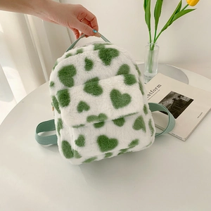 Cute plush cow print backpack with green heart patterns and adjustable straps