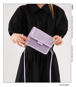 Close-up of light purple rhinestone crossbody bag with flap closure and slim leather strap