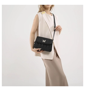 Detail of black quilted leather shoulder bag with silver butterfly metal buckle clasp