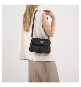 Detail of black pleated leather shoulder bag with silver butterfly clasp and strap