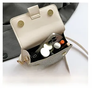 Internal view of cream chain bag showing capacity for smartphone and lipsticks