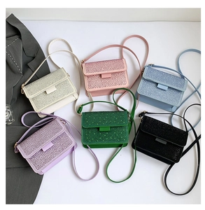 Flat lay of stylish mini crossbody bags with rhinestone details in multiple colors