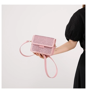 Close-up of pink rhinestone handbag showing sparkling crystal texture and flap closure