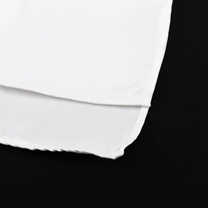 Detail eines weißen Satinoberteils mit feiner Naht und asymmetrischem Vokuhila-Saum-Design
