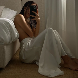 Elegant white satin maxi skirt with high waist and side slit in draped glossy fabric
