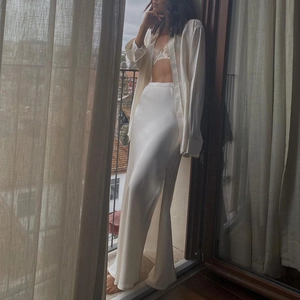 Detail of elegant satin maxi skirt with side slit in cream white silk fabric