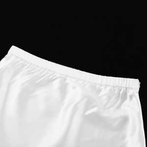 Detailed view of elastic waist on white satin maxi skirt with smooth silky texture