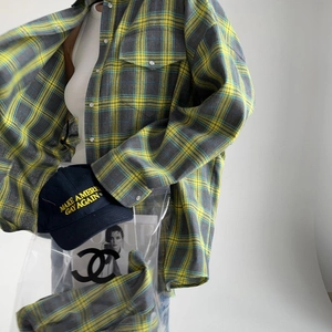 Détail d'une chemise en flanelle à carreaux avec poche poitrine et casquette brodée