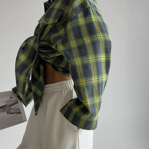 Détail d'une chemise en flanelle à carreaux avec nœud à la taille et texture douce