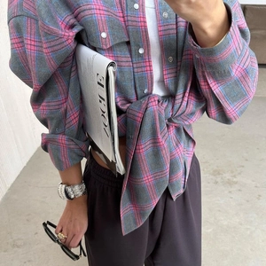 Détail d'une chemise à carreaux rose avec boutons argentés et poche à rabat