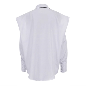 Détail de la chemise blanche à manches longues avec cape d'épaule et poignets à trois boutons