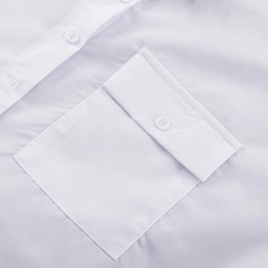 Détail d'une chemise blanche présentant une poche à rabat et des boutons en résine