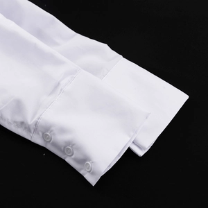 Détail rapproché des poignets de chemise blancs avec trois boutons et finitions soignées