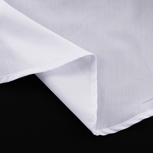 Détails macro du tissu blanc et finitions des coutures sur l'ourlet de la chemise