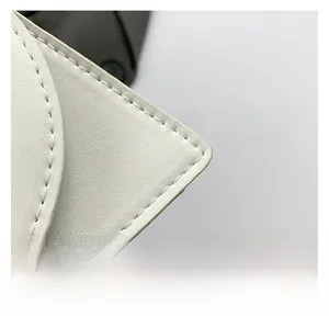 Macro detail of high-quality white lychee leather texture and precise stitching craftsmanship