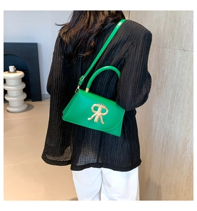 Close-up of vibrant green leather handbag with golden metal R logo and top handle