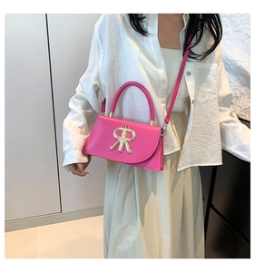 Detail of hot pink crossbody bag featuring a large gold RR metal buckle and smooth leather
