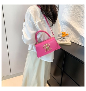 Détail du sac bandoulière rose fuchsia avec boucle logo R dorée en situation réelle