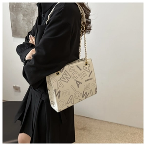 Detalle de bolso de hombro con cadena y estampado con adornos dorados y QIANWEI