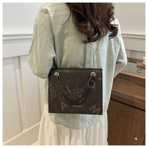 Detail view of brown vintage tote bag with letter print and golden chain strap for women