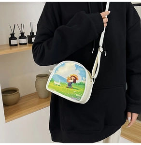 Detail of white canvas crossbody bag with colorful girl and cat illustration in use