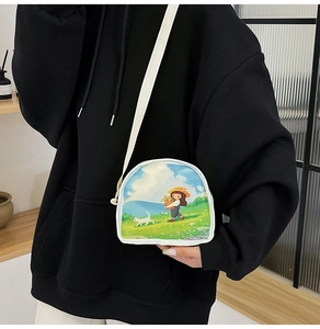 Detail of canvas crossbody bag featuring pastoral illustration and white fabric strap