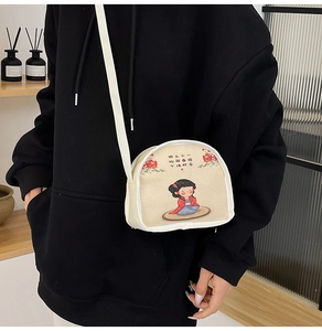 Detail of cream canvas crossbody bag with Chinese cartoon print and motivational text
