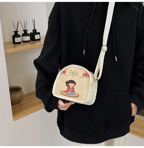 Detail of canvas crossbody bag with Chinese cartoon illustration and adjustable strap