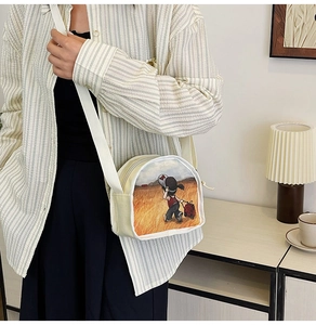 Detail of canvas half-moon bag featuring an artistic girl illustration and adjustable strap