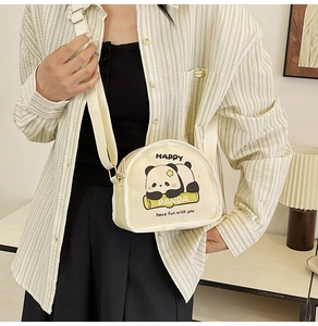 Detail of canvas crossbody bag showing cartoon panda print and adjustable strap