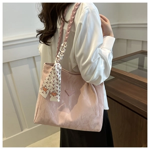 Detail van roze hobo tas met geweven riem en decoratieve bedrukte zijden sjaal decoratie