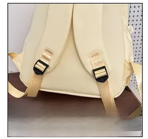 Detail showing the widened nylon shoulder strap and adjustable black buckle on the beige backpack