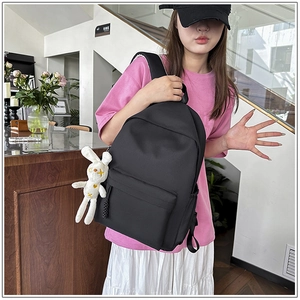 Black minimalist nylon backpack with a cute white rabbit plush charm for school