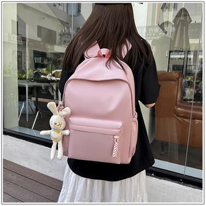 Pink minimalist nylon backpack featuring a cute white rabbit plush charm accessory