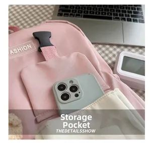 Detailed view of pink backpack storage pocket holding a smartphone for capacity display