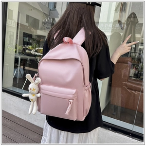Pink school backpack detail featuring a cute white rabbit plush pendant on the side pocket