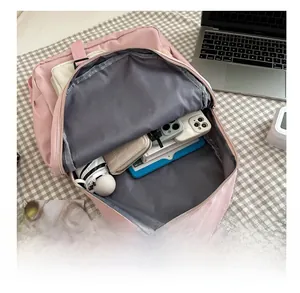 Pink canvas backpack detail showing spacious grey main compartment and storage capacity
