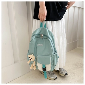 Detail of mint green nursery backpack with fashion tag and cute bear pendant charm