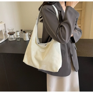 Gros plan du grand sac cabas crème avec texture marbrée et bandoulière sur le modèle