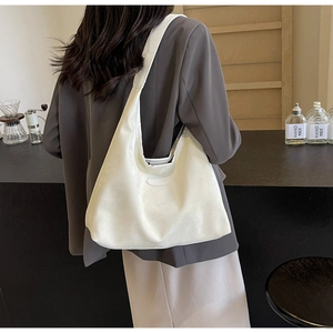 Détail d'un grand sac hobo beige en cuir mat avec surpiqûres sur la bandoulière large