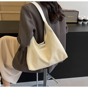 Détail macro du sac hobo blanc crème montrant la texture mate et la large bandoulière