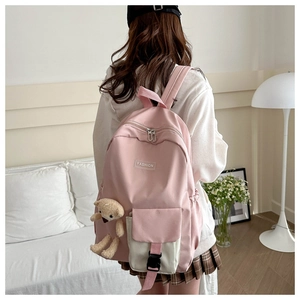 Detailed side view of a pink and white laptop backpack with a cute plush bear pendant